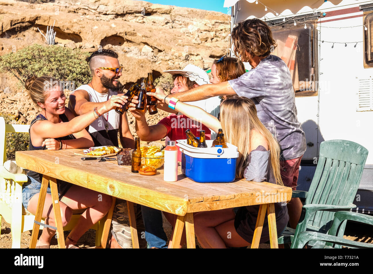 Groupe de personnes jeunes, hommes et femmes, le grillage avec bières dans l'amitié une activité de loisirs - camping des vacances locations Banque D'Images