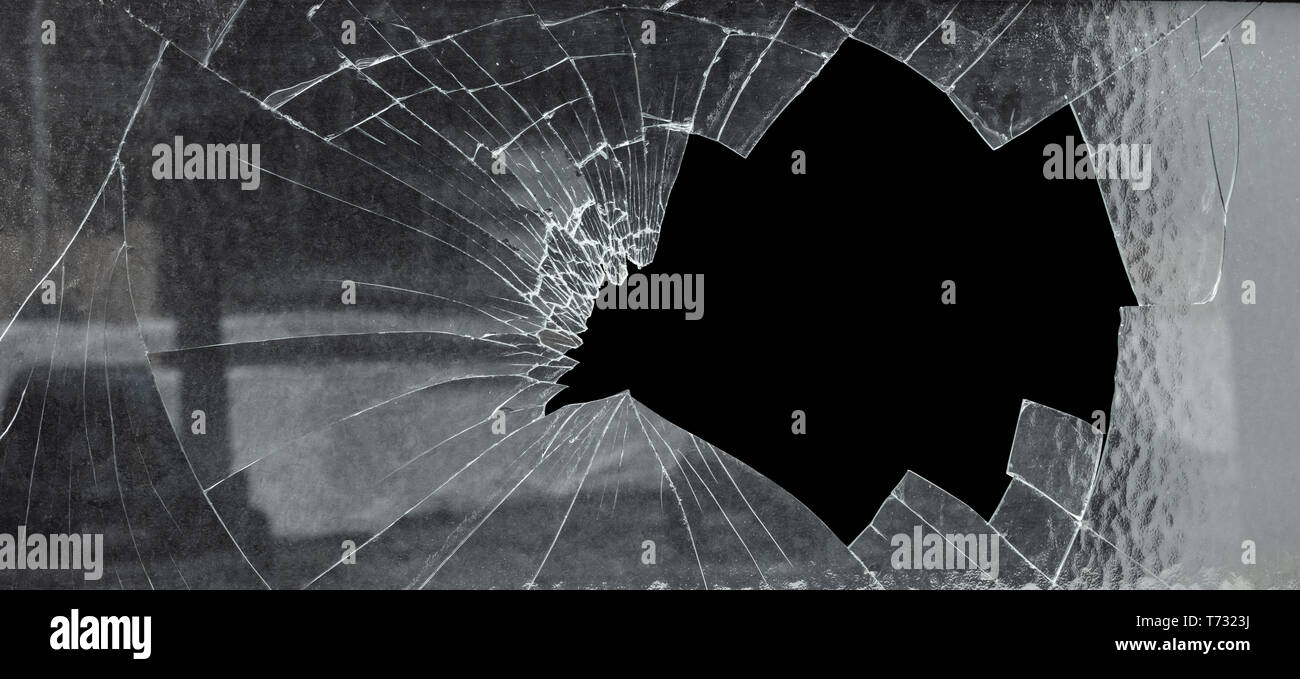Verre fissuré brisé avec gros trou sur fond noir Banque D'Images