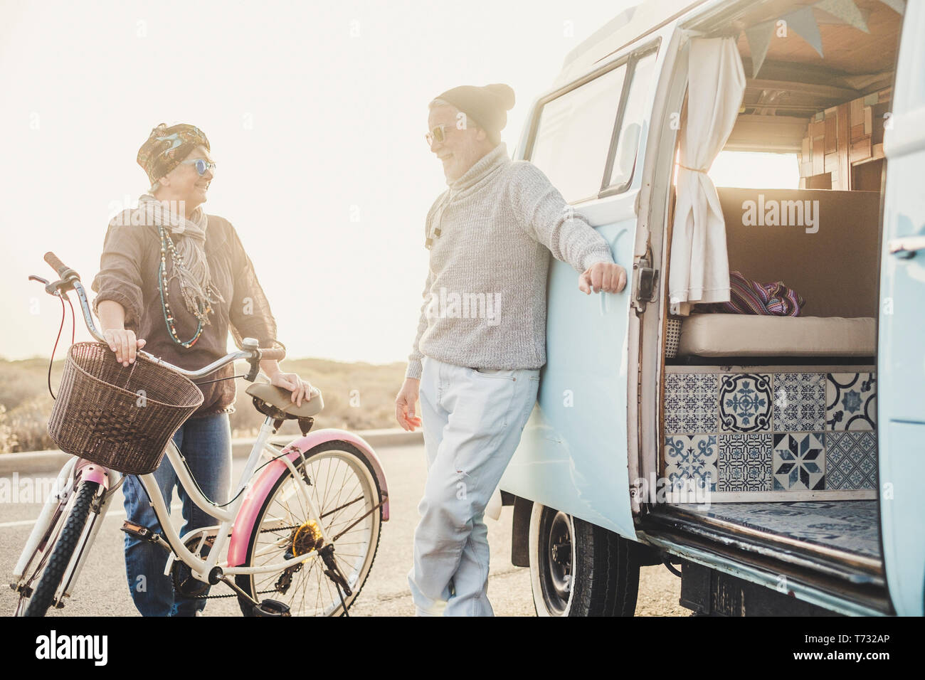 Les gens heureux couple d'âge senior sourire et profiter des services et activité de loisirs avec vintage bike et van pour les vacances d'conc Banque D'Images