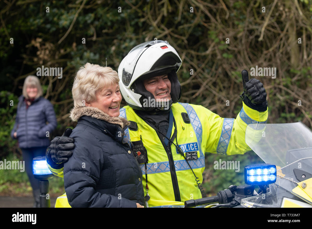 Un automobiliste de police portant un casque d'accident et une veste haute visibilité posant pour une photo sur la scène féminine du Tour de Yorkshire à Harrogate, au Royaume-Uni. Banque D'Images