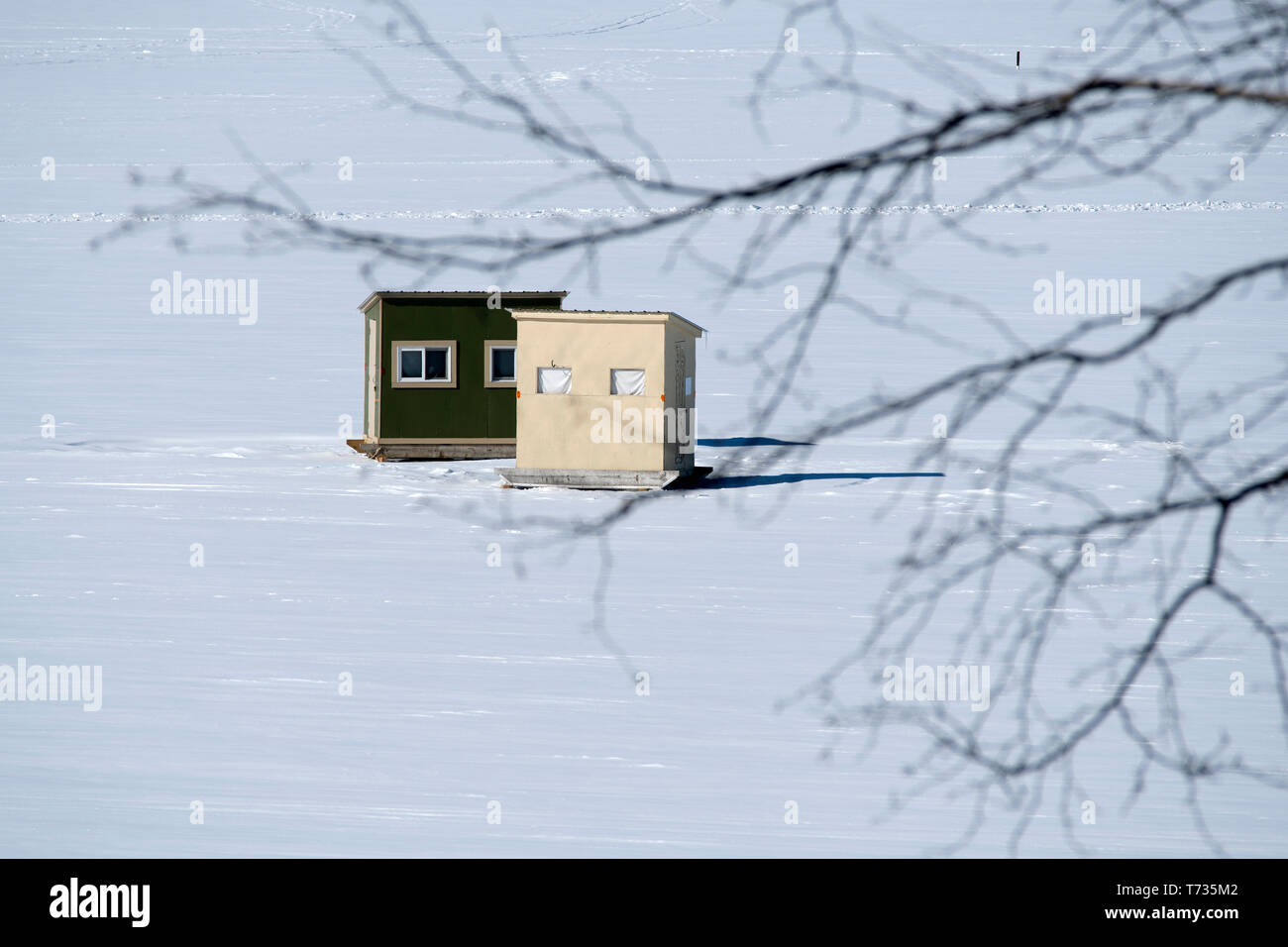 Deux baraques utilisées pour la pêche blanche sur un lac gelé recouvert de neige en Nouvelle Angleterre. C'est un sport d'hiver populaire dans les communautés rurales de la Nouvelle Angleterre. Banque D'Images