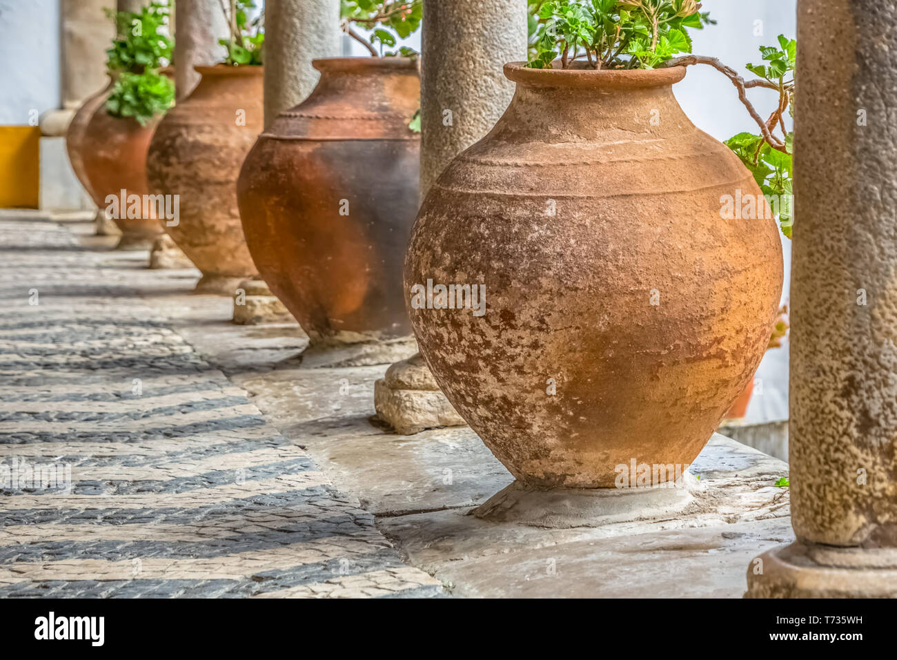 Voir l'arcade médiévale avec orange vases en céramique et colonnes de granit antique à Obidos, Portugal Banque D'Images