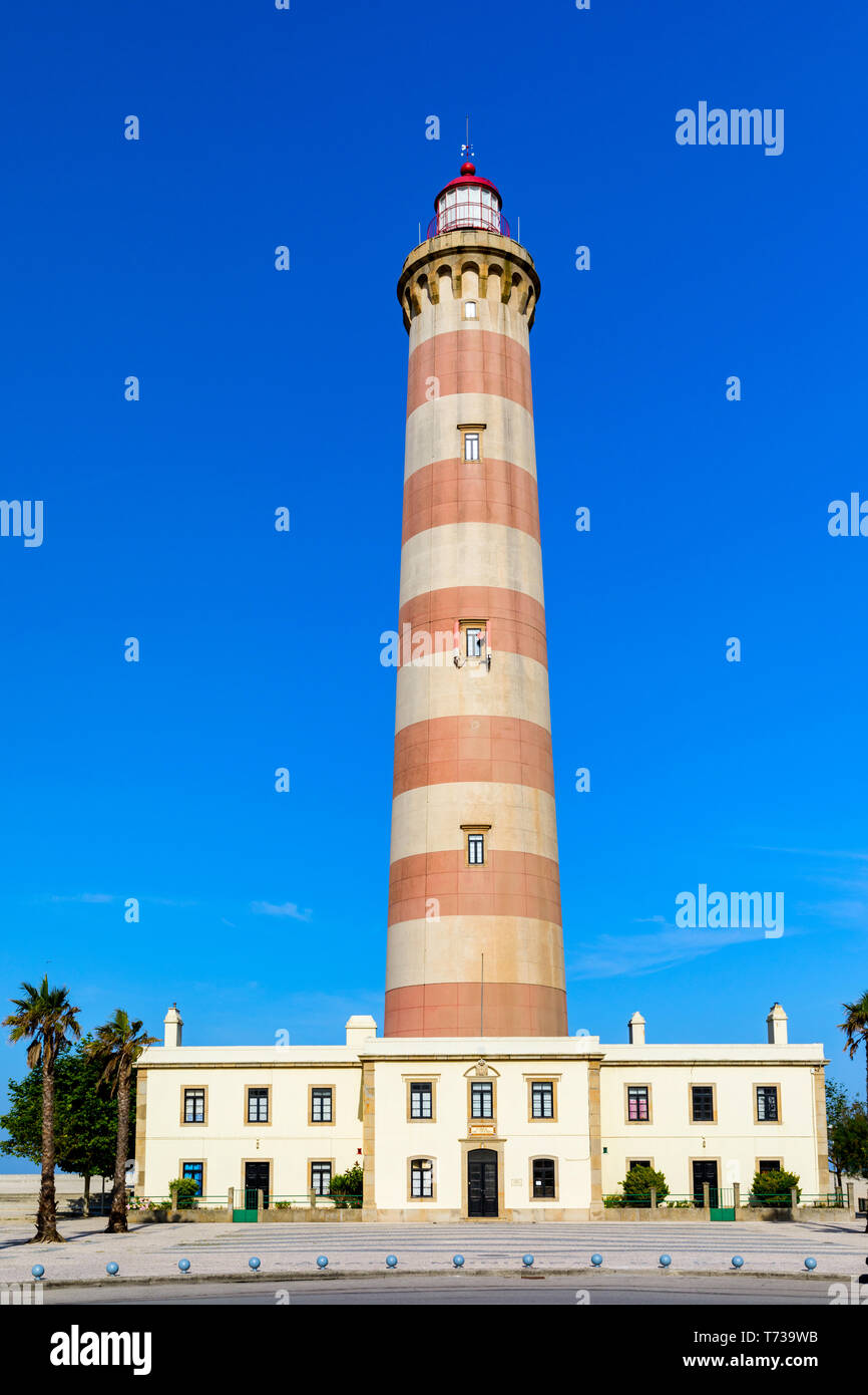 Phare de Praia da Barra pendant la journée, avec un ciel bleu clair. Vue sur le phare de Barra Beach (Praia da Barra) à Aveiro, Portugal. Banque D'Images