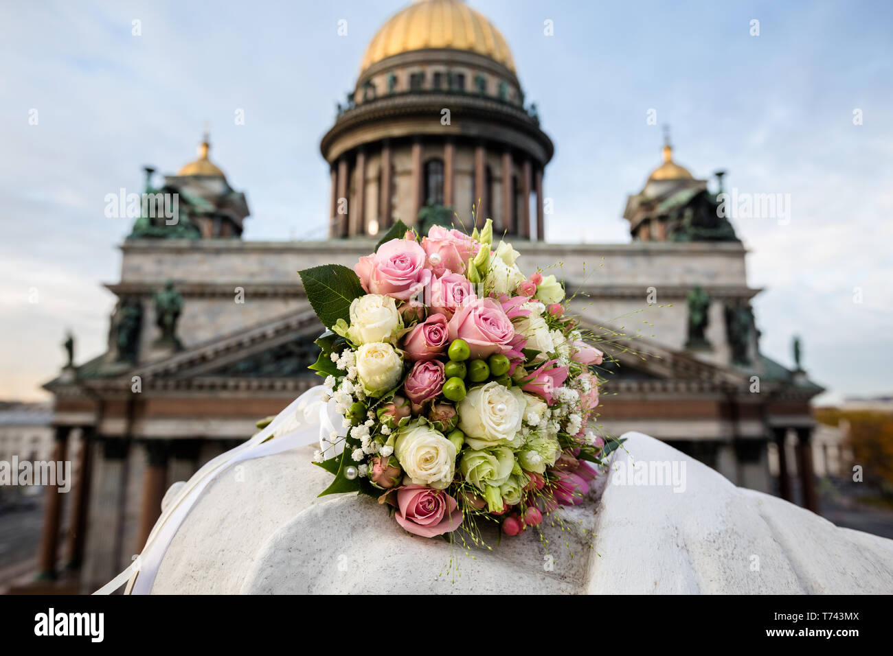 Boutons de roses blanches et roses dans un bouquet de mariage dans l'arrière-plan de la cathédrale Banque D'Images