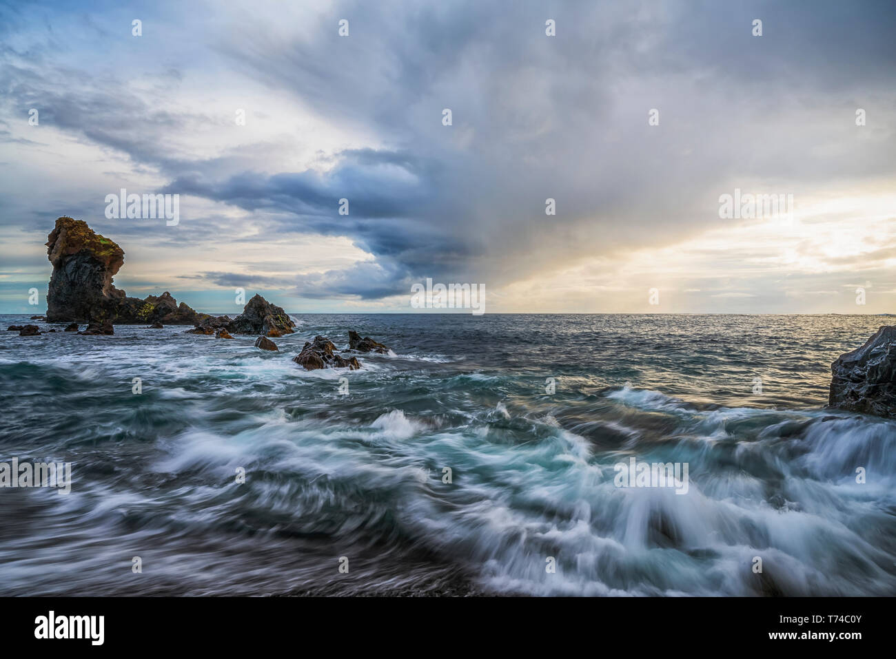 Les vagues déferlent sur le rivage de Djupalonssandur beach au coucher du soleil, la péninsule de Snaefellsness Islande ; Banque D'Images