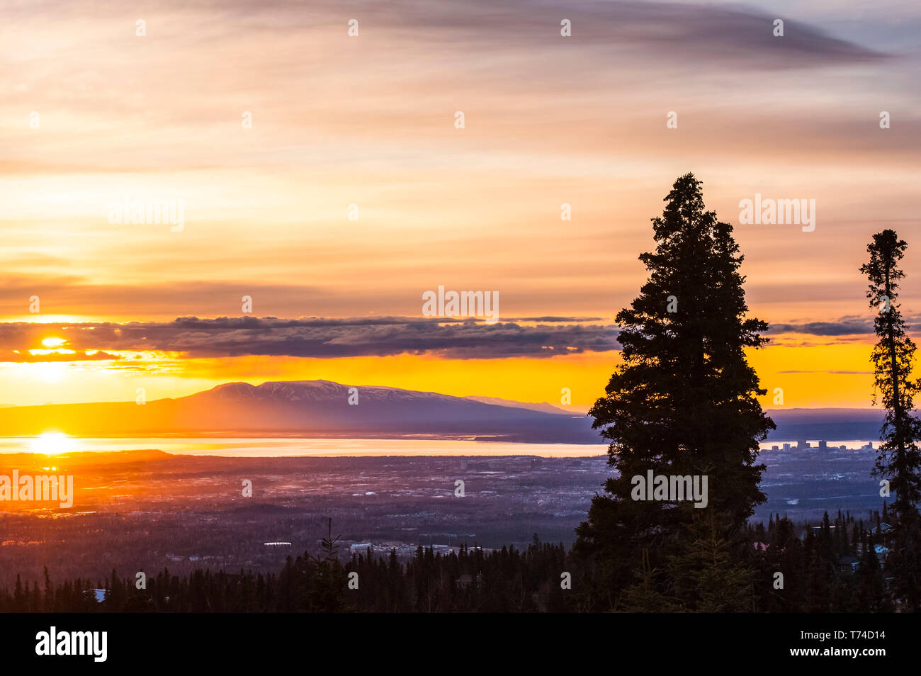 Le soleil couchant sur le Mont Susitna de l'Alaska, connu localement sous le nom de 'la Dame de dormant', avec le point de vue de Cook Inlet et la ville d'Anchorage en premier plan ... Banque D'Images