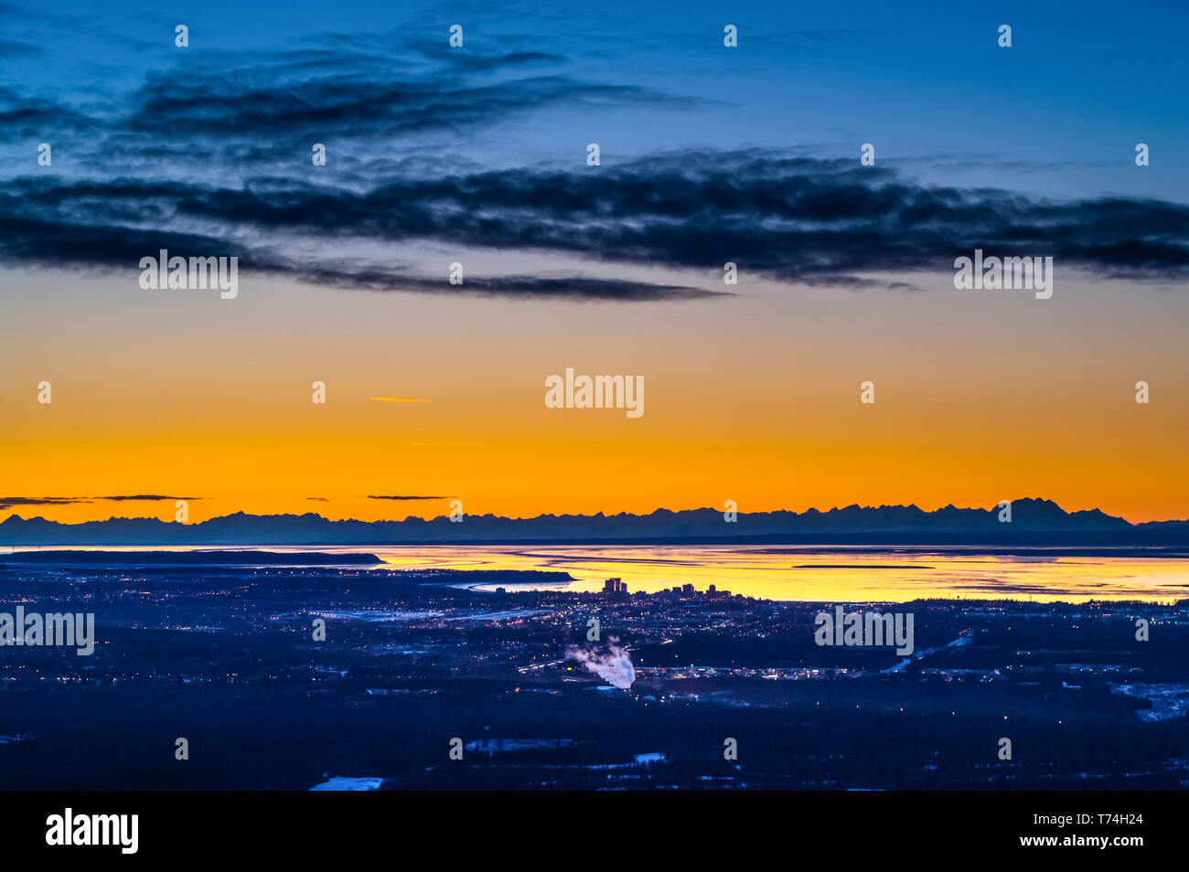 Anchorage, Alaska, vu de la route de la vallée de l'Arctique alors que le soleil se couche sur un winters la nuit. Le Cook Inlet et de la chaîne de l'Alaska sont à l'arrière-plan Banque D'Images