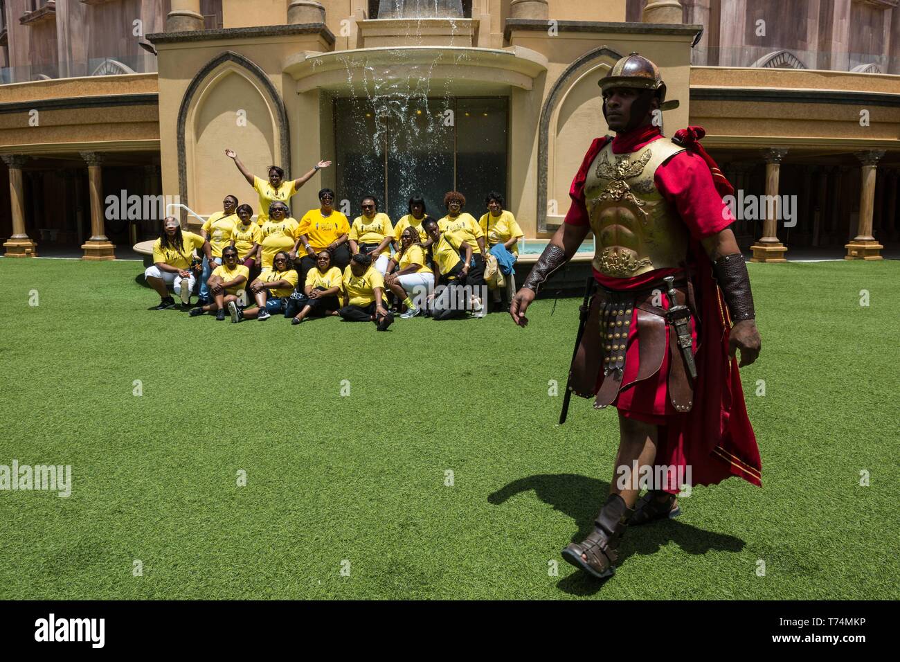 Orlando, Floride, USA. 3 mai, 2019. Les femmes en visite de Caroline du Sud posent pour une photo de groupe comme un acteur dans un costume romain promenades par à la terre sainte de l'expérience (HLE) à Orlando, Floride. Le parc à thème, appartenant à la Trinity Broadcasting Network, recrée l'architecture et les thèmes de l'ancienne ville de Jérusalem au 1er siècle, la Judée. Les aciers HLE est une vie chrétienne non confessionnelle et de l'église musée biblique. Il y a plusieurs spectacles à thème religieux donnés tout au long de la journée dans différents endroits, à l'intérieur et l'extérieur. Credit : Tracy Barbutes/ZUMA/Alamy Fil Live News Banque D'Images