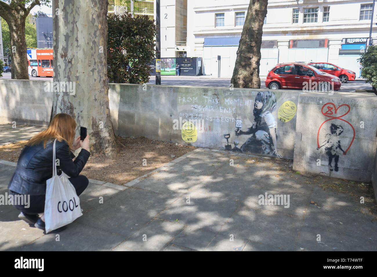 Londres, Royaume-Uni. 4 mai, 2019. Une nouvelle œuvre d'art authentique par Banksy a été couverte en verre plexiglas contre les dommages à l'endroit où le changement climatique rébellion Extinction manifestants ont protesté et ont campé pendant plus d'une semaine à Marble Arch. La murale caractéristiques le slogan "a partir de ce moment, le désespoir se termine et la tactique commencer" à côté d'une jeune fille assise sur le sol tenant une rébellion Extinction Crédit logo : amer ghazzal/Alamy Live News Banque D'Images
