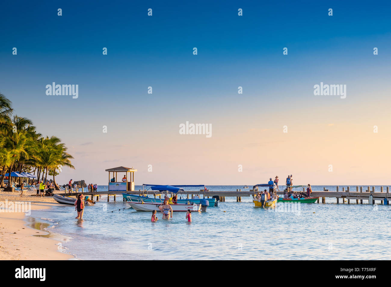 Les personnes bénéficiant d'une chaude soirée de coucher du soleil à West Bay, Roatan Honduras Banque D'Images