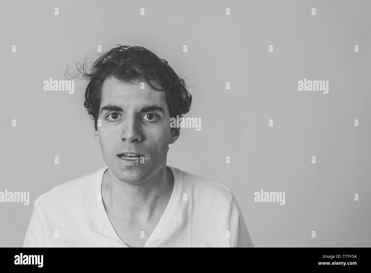 Le noir et blanc portrait de jeune homme de race blanche se sentir furieux. À pissé et contrarié . Studio shot. Dans les gens et les expressions faciales et n Banque D'Images