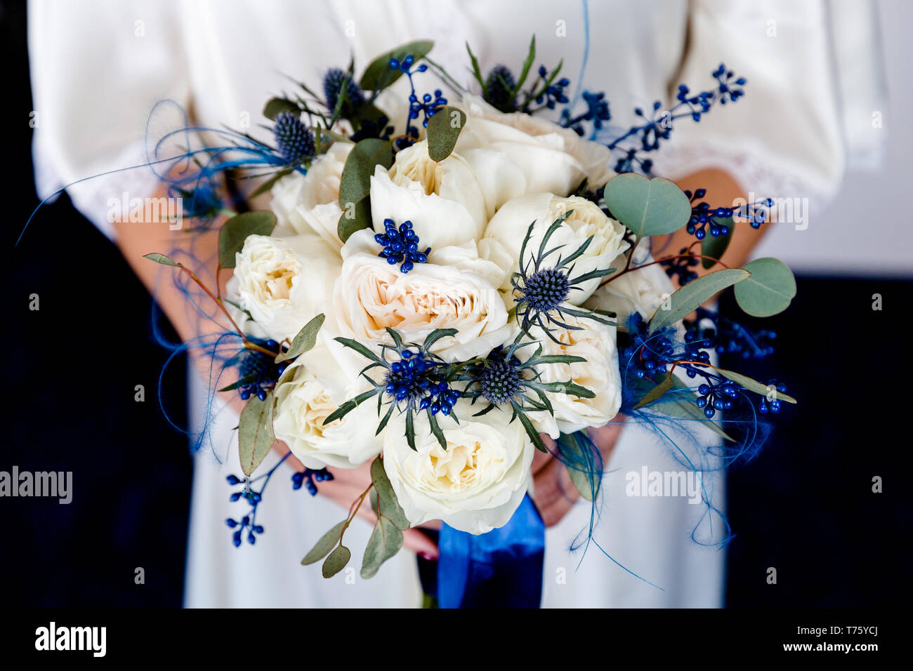 Bouquet de roses blanches à fleurs bleues dans les mains de la mariée Photo  Stock - Alamy