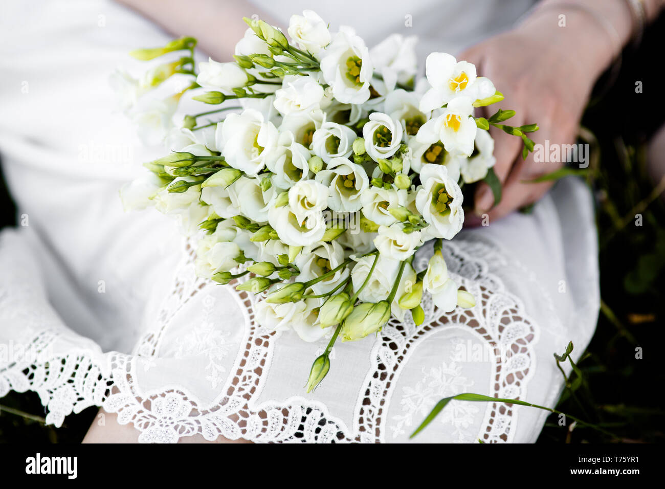 Bouquet de mariée exquise d'eustoma Blanche-neige dans les mains d'une femme méconnaissable Banque D'Images