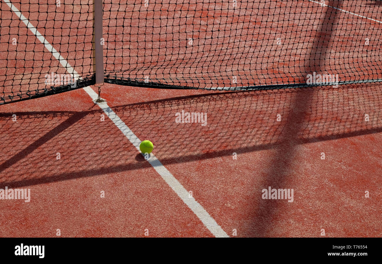 Balle de tennis en face d'un filet de tennis sur un court de tennis Banque D'Images