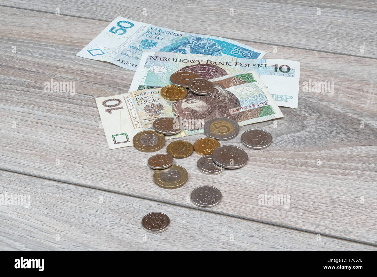 Certains billets et quelques pièces de zloty polonais sur une table en bois Banque D'Images