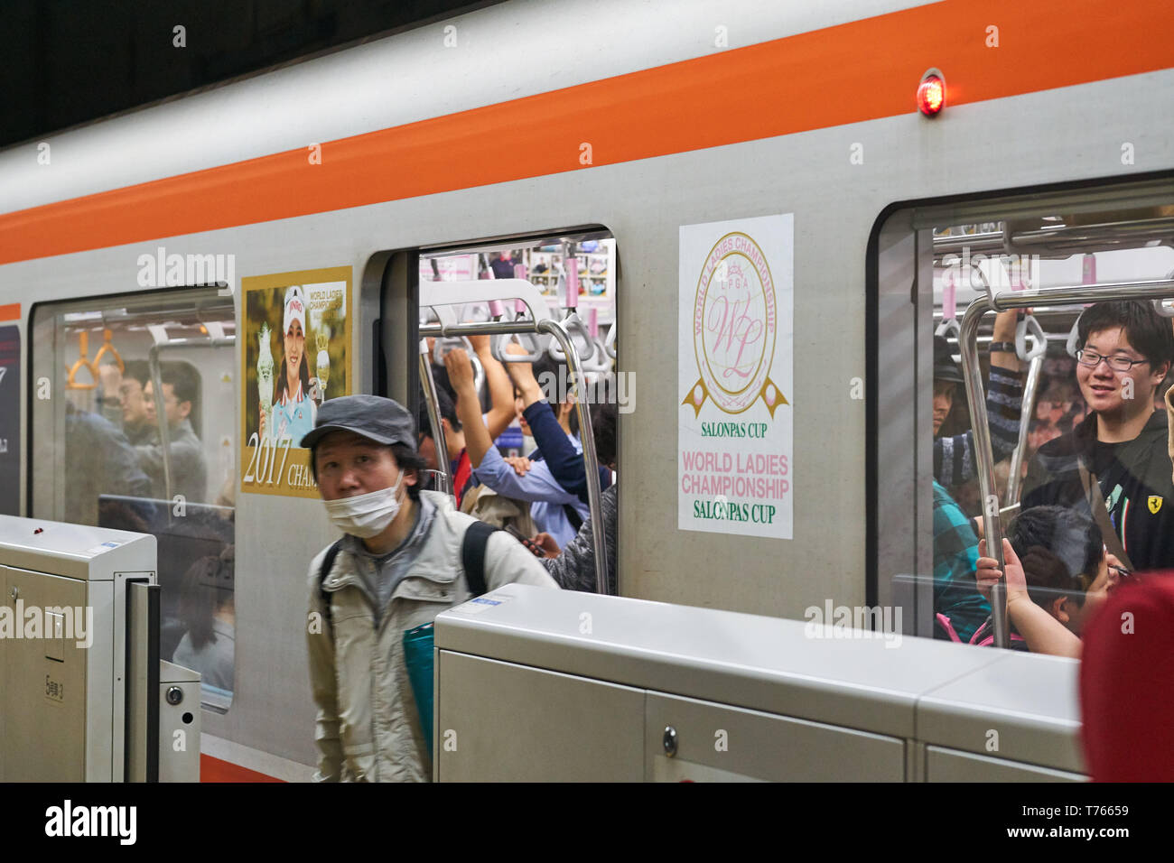 Un adulte homme japonais portant un masque chirurgical débarque d'une voiture de train sur la ligne Tsukuba Express à la gare d'Asakusa, Tokyo, Japon. Banque D'Images