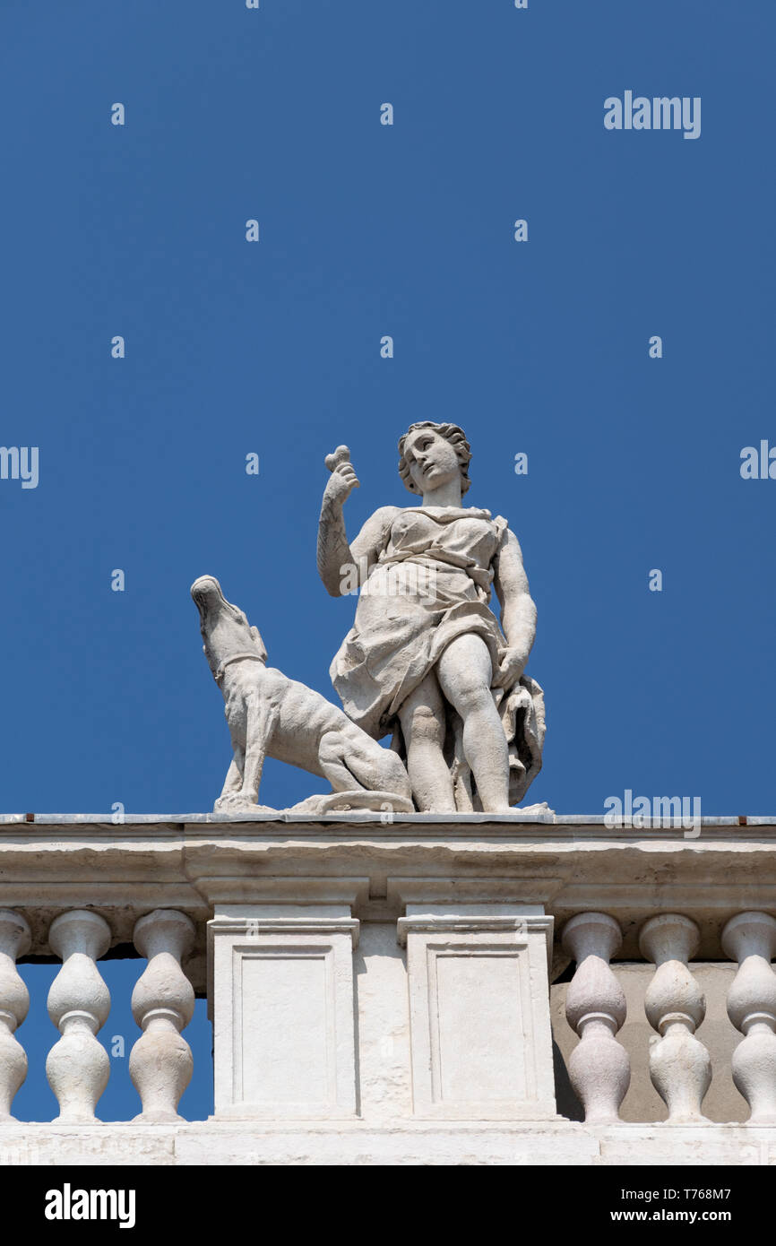 Détail de la statue depuis le toit du Palazzo Canossa, Corso Cavour, Vérone, Italie, figure féminine qui fait un os à un chien Banque D'Images