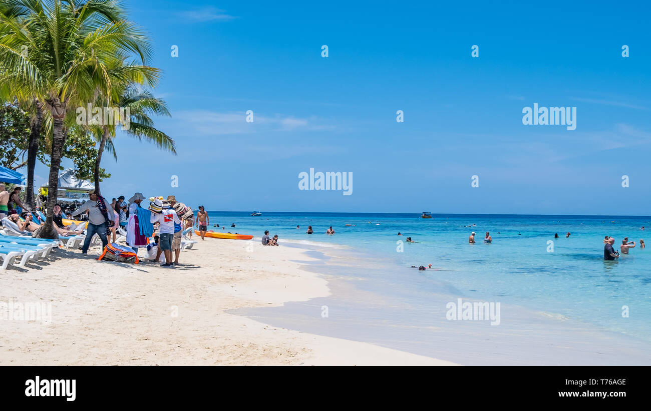 Les gens sur la plage de West Bay, Roatan Honduras sous le soleil d'avril. Banque D'Images