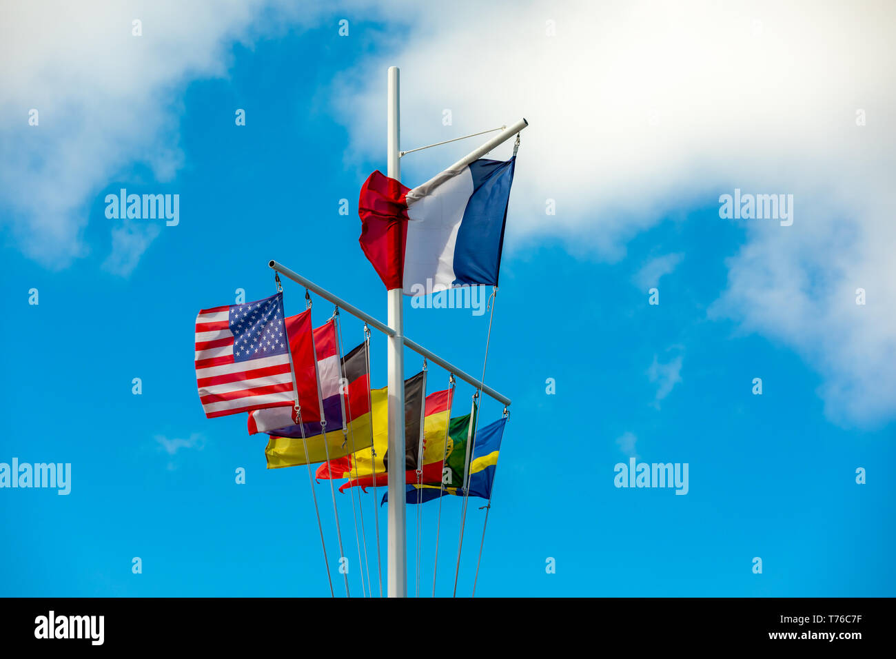 Mât à Gustavia, St Barts avec de nombreux drapeaux à l'affichage contre un ciel bleu Banque D'Images