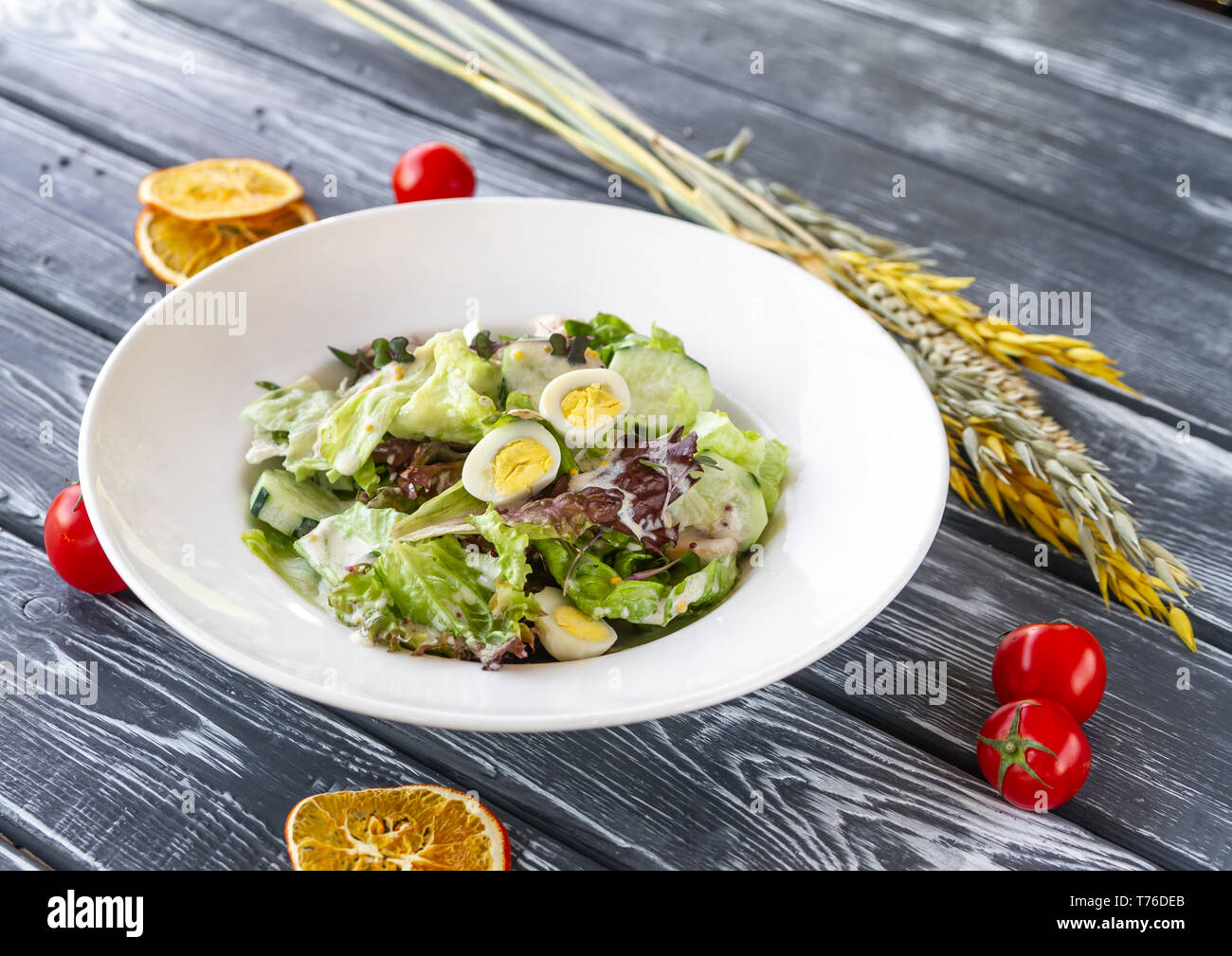 Salade de concombres frais, filet de poulet et les champignons sur la table avec des épillets de céréales, les tomates cerises et les oranges séchées Banque D'Images