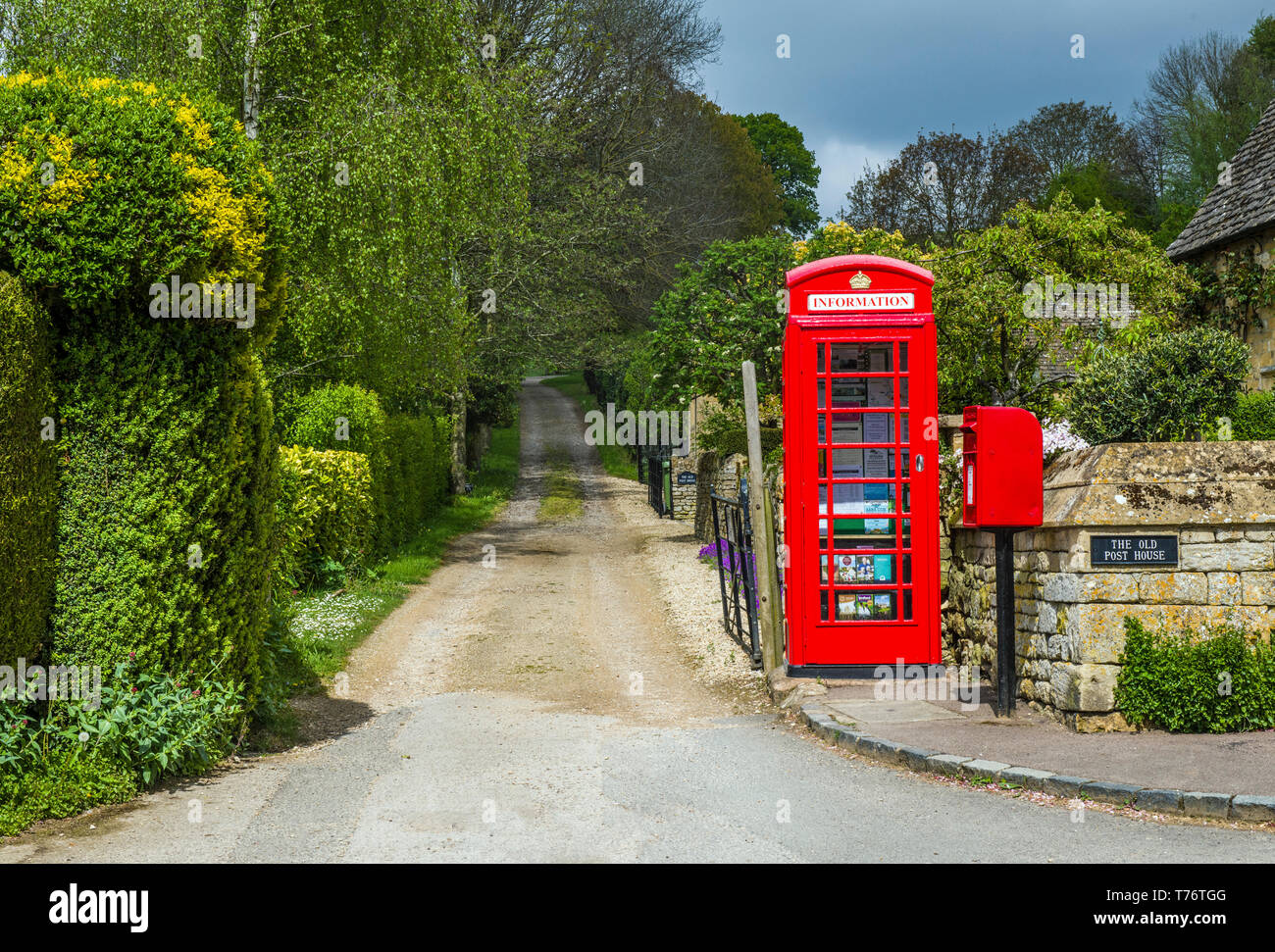 Le village de Cotswold Stanton, près de Broadway, montrant une ruelle avec une boîte de téléphone rouge et red letterbox. Le téléphone contient d'information aux visiteurs. Banque D'Images