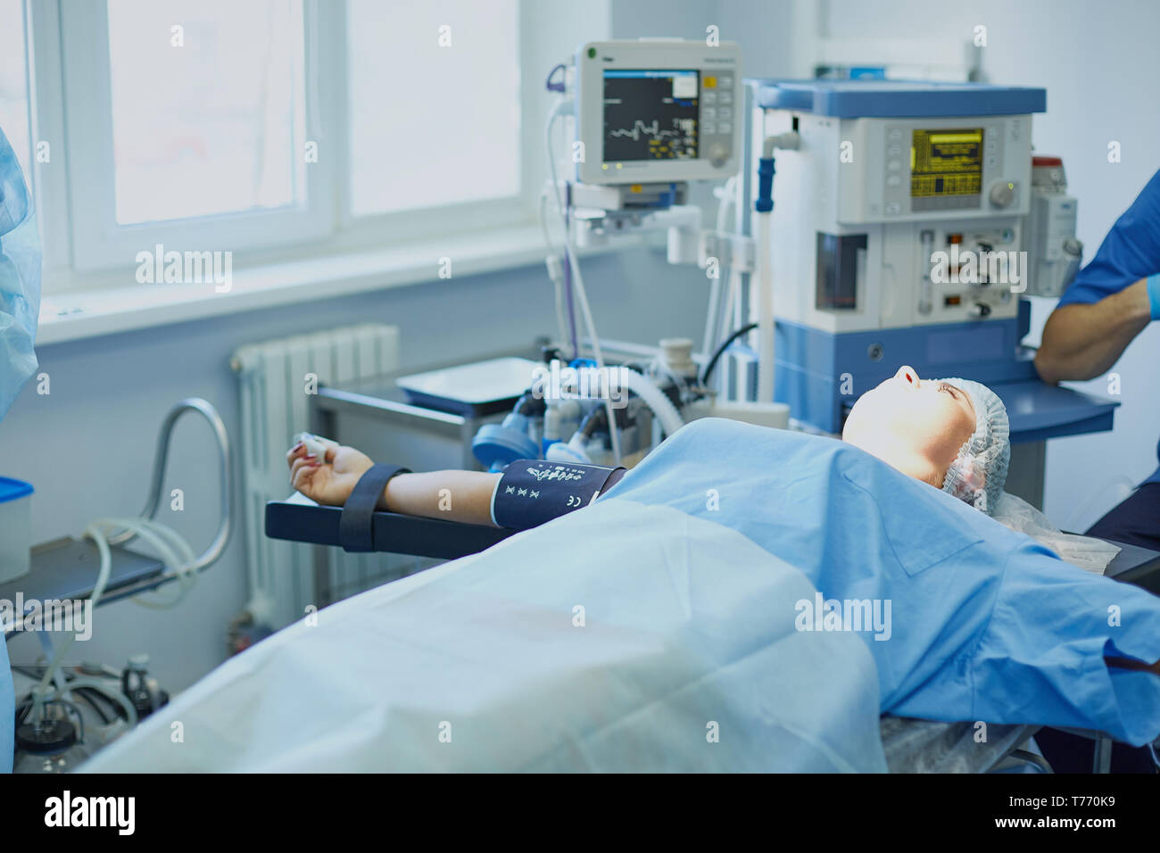 Plusieurs médecins entourant patient sur table d'opération pendant leur travail. Les chirurgiens de l'équipe au travail en salle d'opération. Banque D'Images