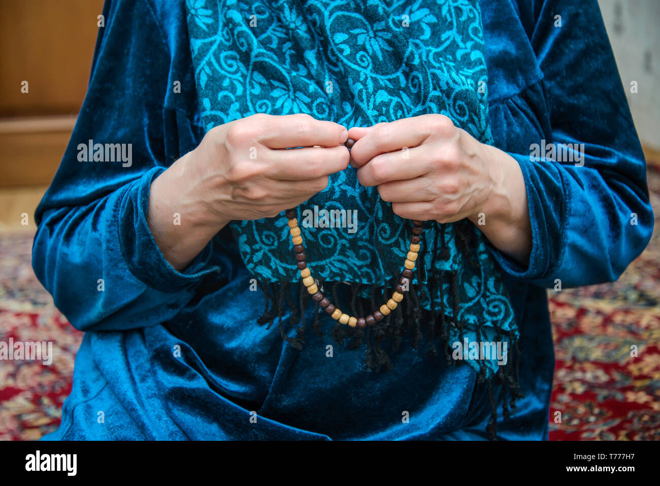 Chapelet musulman dans les mains d'une vieille femme en prière dans une robe et foulard, Ramadan Banque D'Images