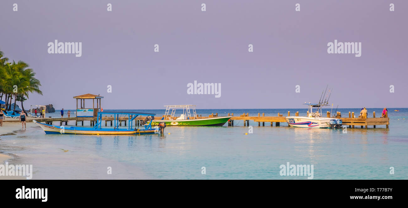 Bateaux de pêche attendent les touristes à West Bay à Roatan Honduras. Banque D'Images
