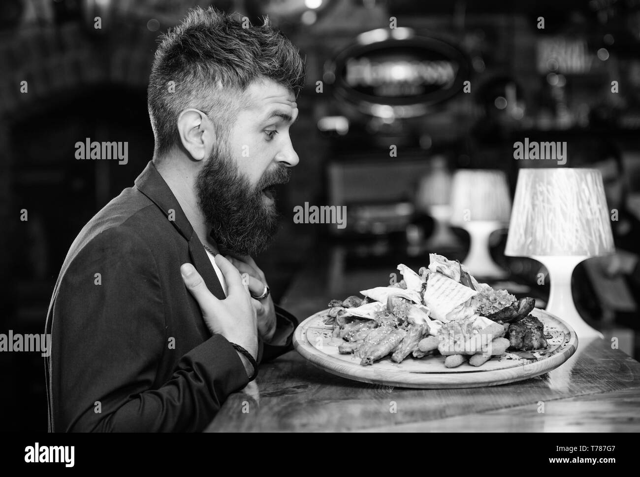 L'homme a reçu de pommes de terre frites repas avec les bâtonnets de poisson viande. Il méritent de délicieux repas. Profitez de votre repas. Des calories. Vous pourrez vous détendre après une dure journée. La nourriture délicieuse. Woman costume formel s'asseoir au restaurant. Banque D'Images
