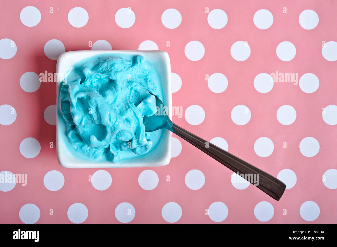 Blue Ice cream dans un bol blanc sur un fond bleu à pois rose Banque D'Images