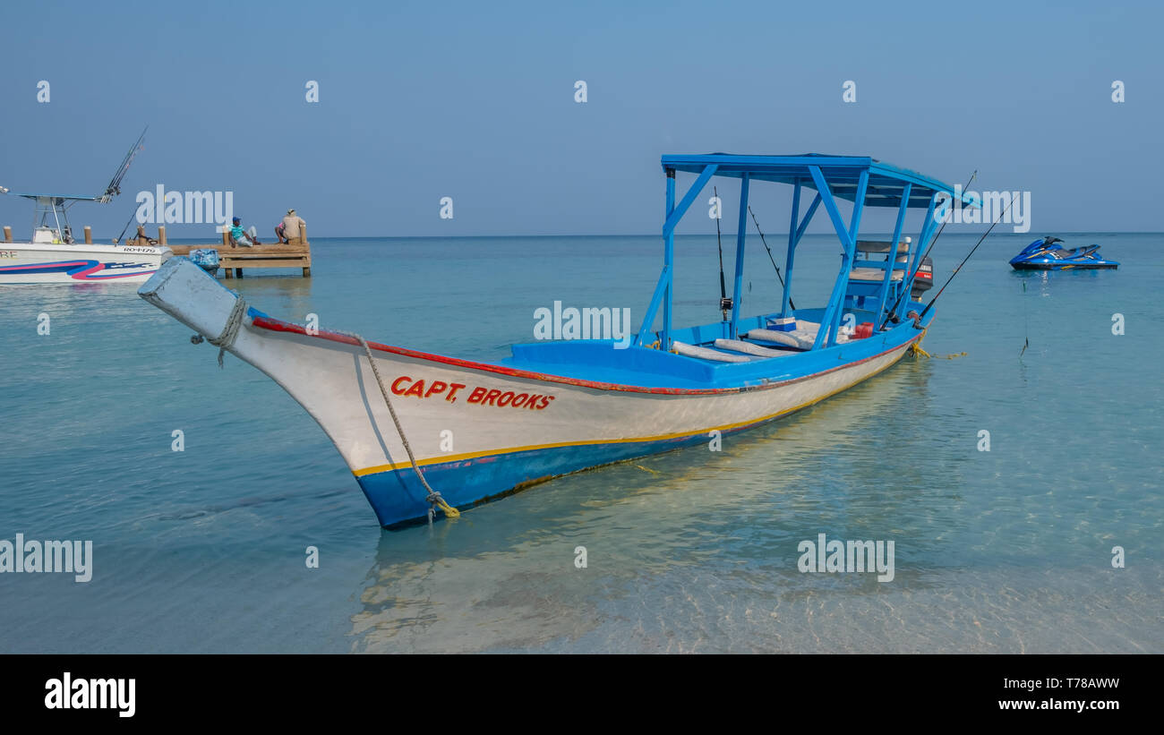 Bateau traditionnel en bois utilisé comme bateau de pêche touristique dans la baie Wesy Roatan Honduras. Banque D'Images