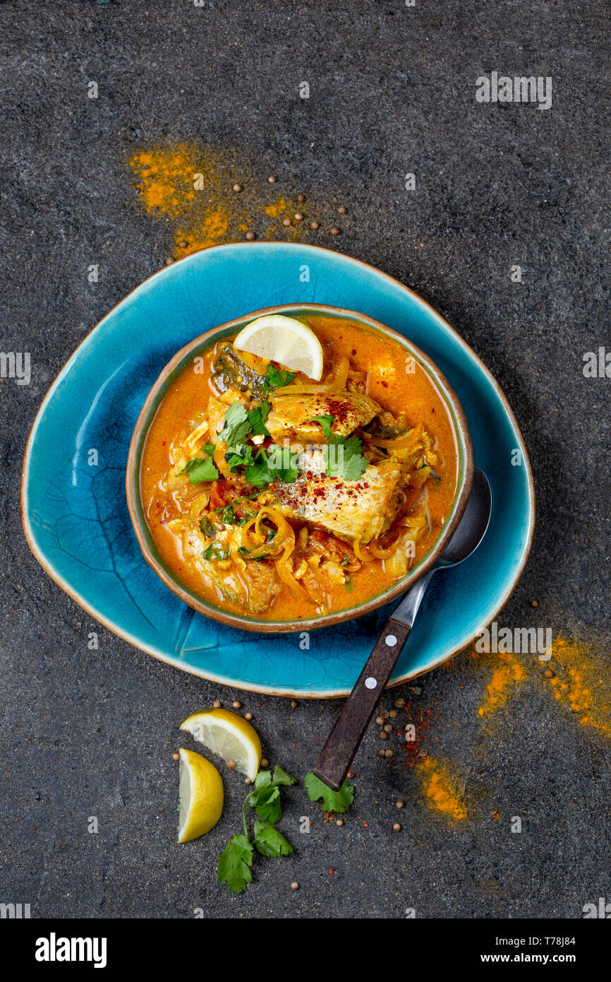 Nourriture indienne. KERALA traditionnel curry de poisson avec du pain naan, gris, plaque de fond noir. Banque D'Images