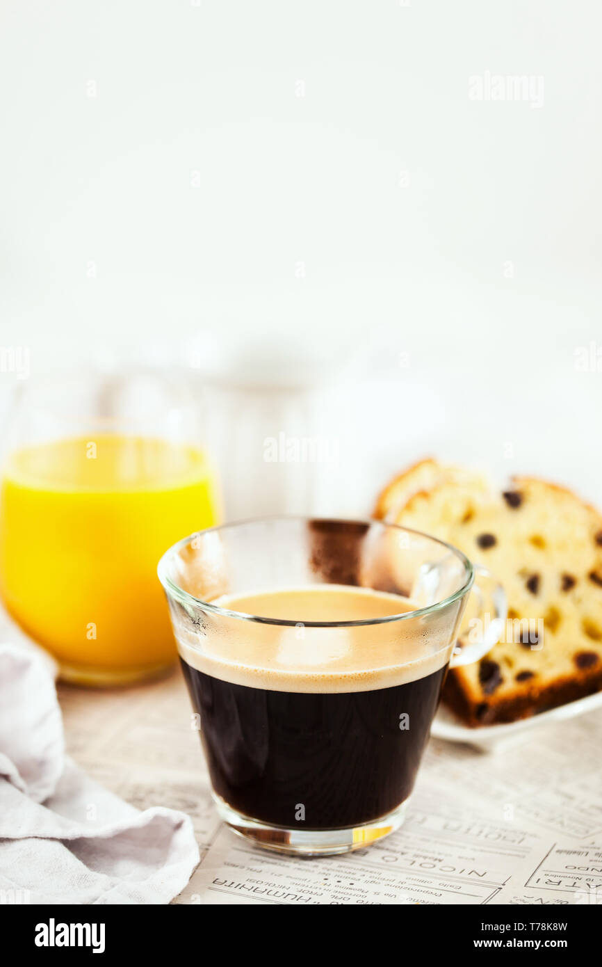 Petit-déjeuner continental table avec tasse de café noir chaud, du lait, des gâteaux et du jus d'orange Banque D'Images