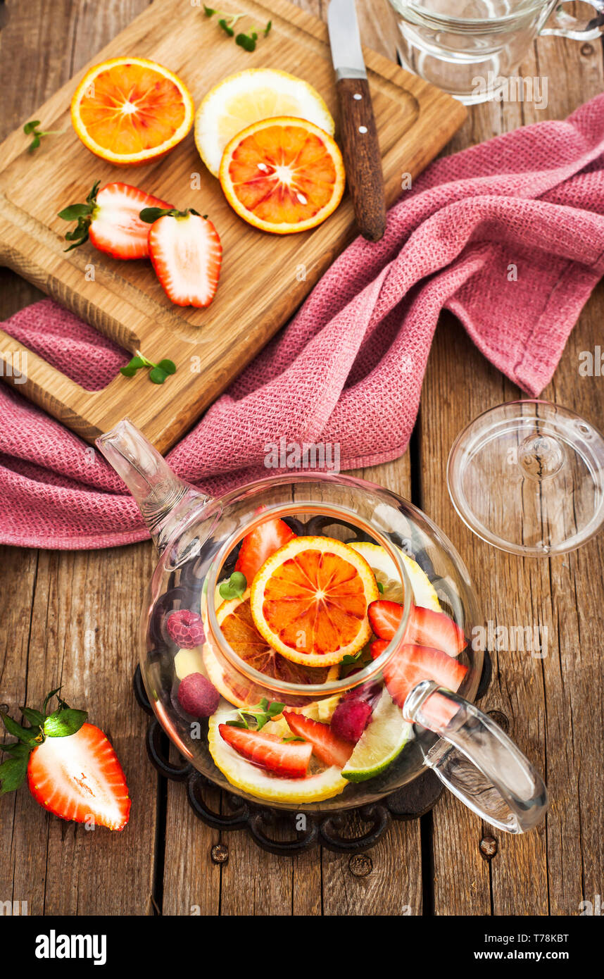 Thé rouge de fruit avec les oranges et les fruits sur la table en bois, vue du dessus Banque D'Images