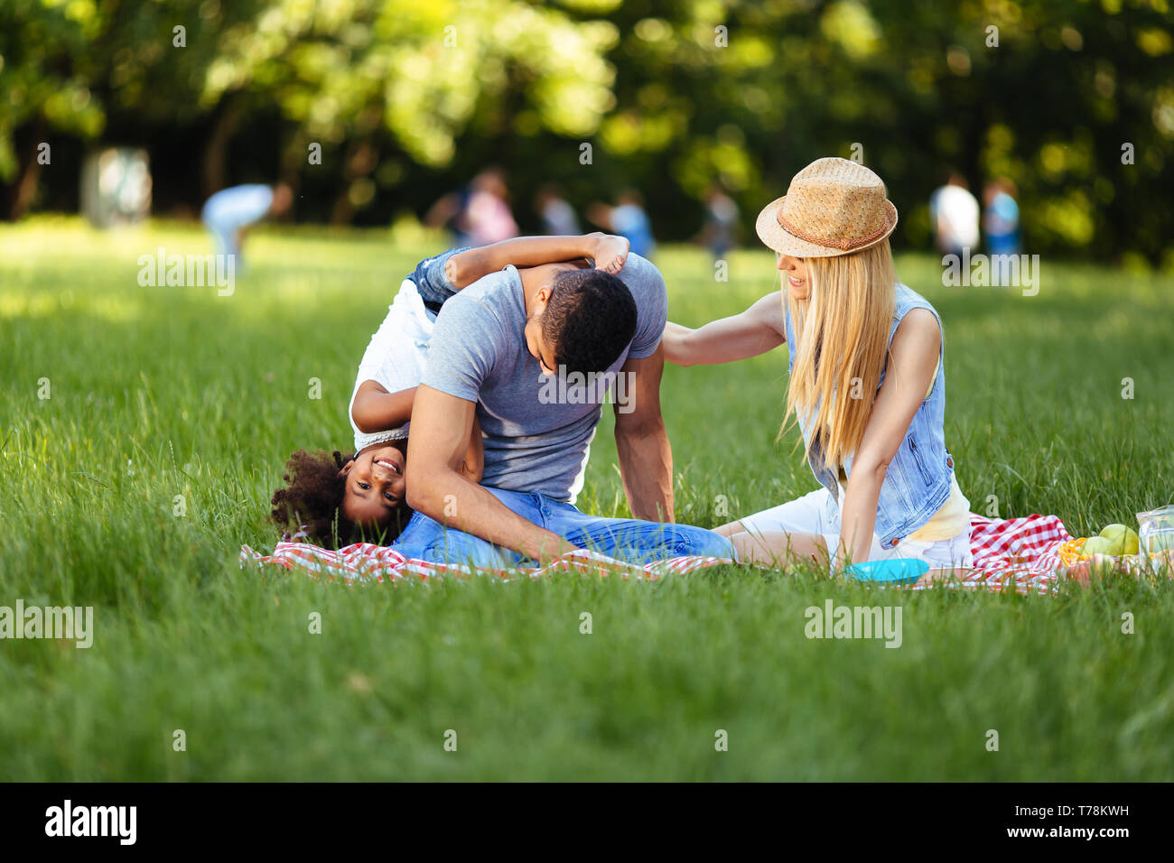 Photo de jolie couple avec leur fille having picnic Banque D'Images