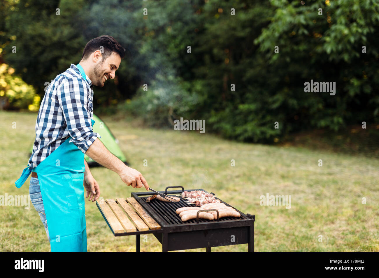 Beau mâle prépare un barbecue Banque D'Images