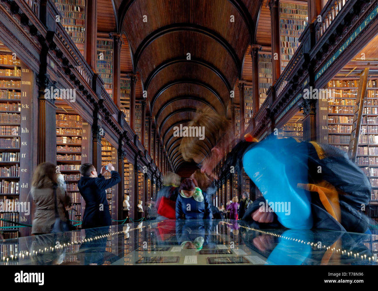 Admirer les vieux livres dans la belle vieille bibliothèque Long Room à Trinity College, Dublin, Irlande Banque D'Images