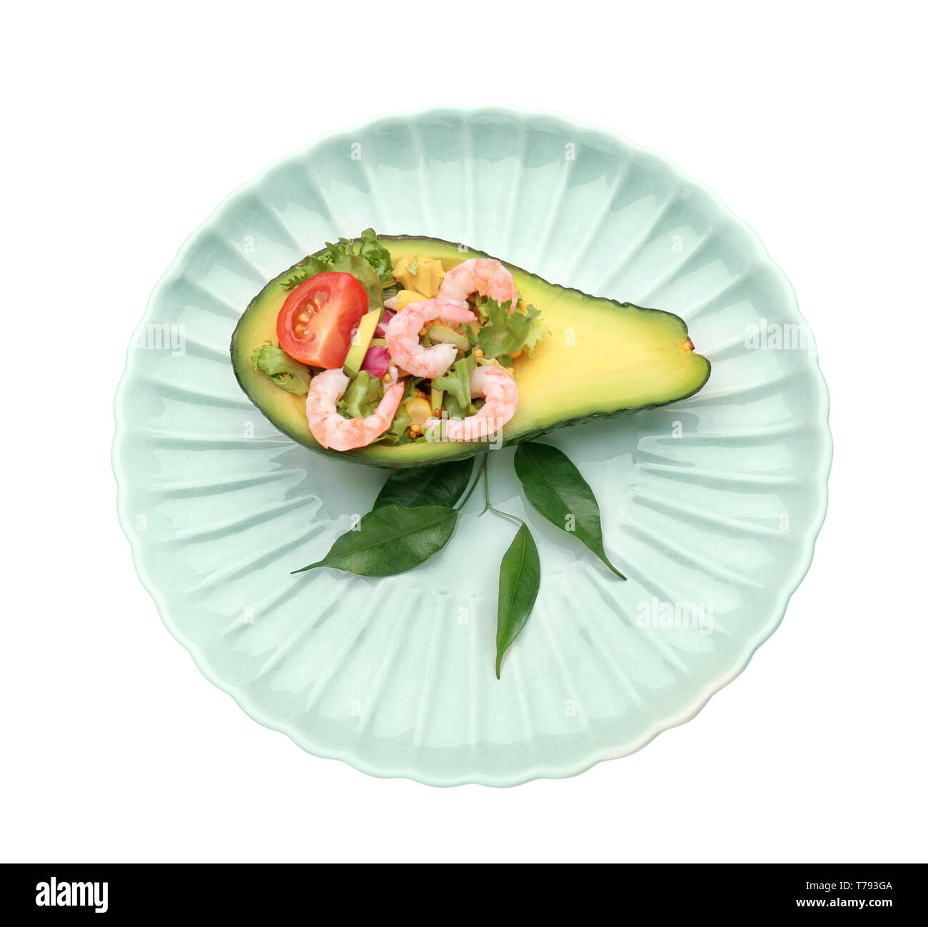 Salade de crevettes savoureuses en bateau sur l'avocat contre la plaque de fond blanc Banque D'Images