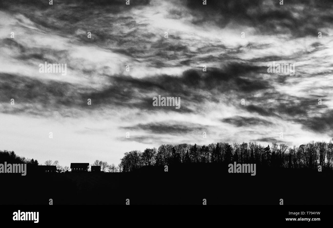 Coucher de soleil avec des nuages lumineux et un arbre, une colline et vallée silhouette dans les Alpes autrichiennes Banque D'Images