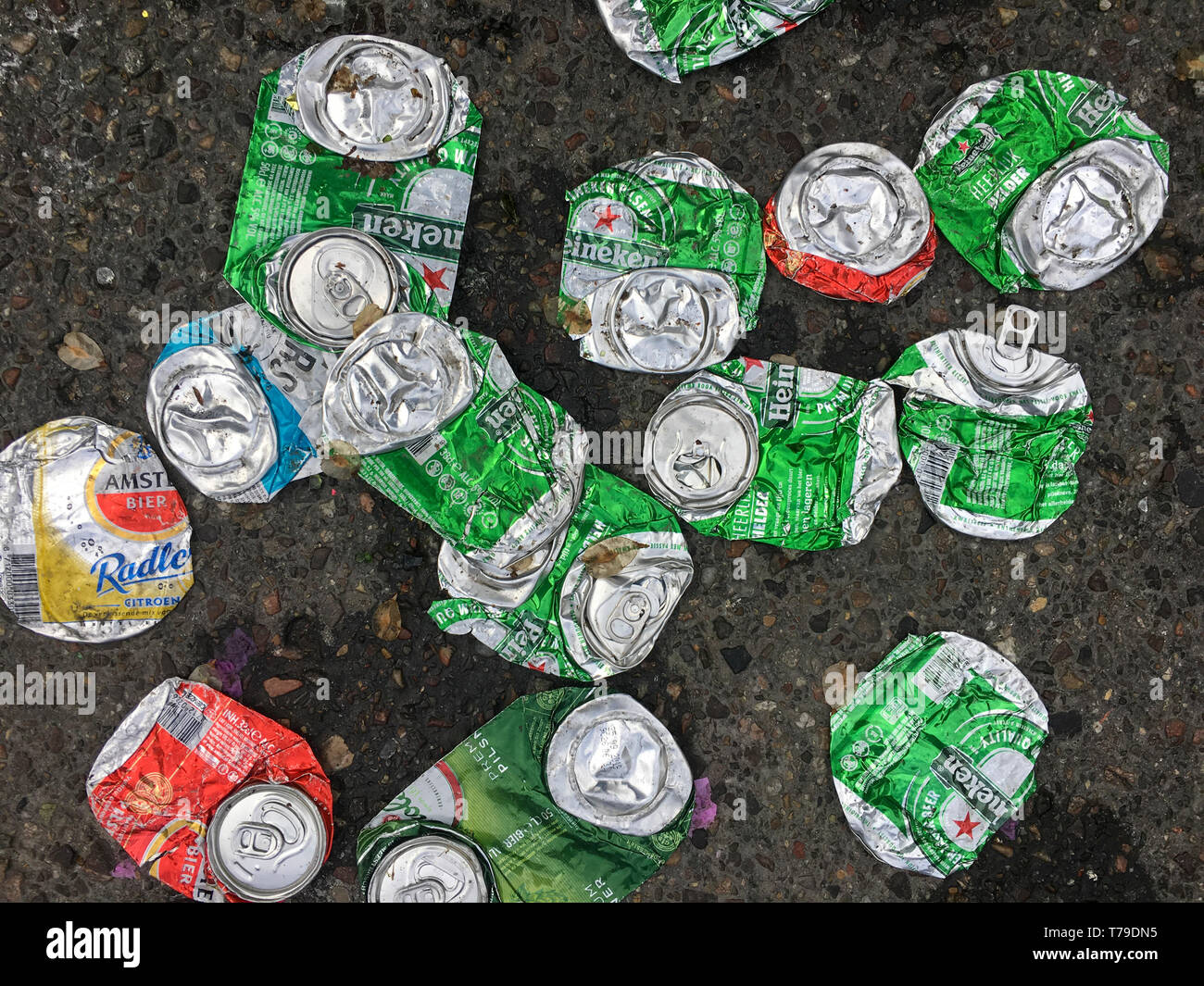 De nombreuses boîtes de bière vides en aluminium sont écrasées jonchant une rue de la ville d'Amsterdam. Banque D'Images