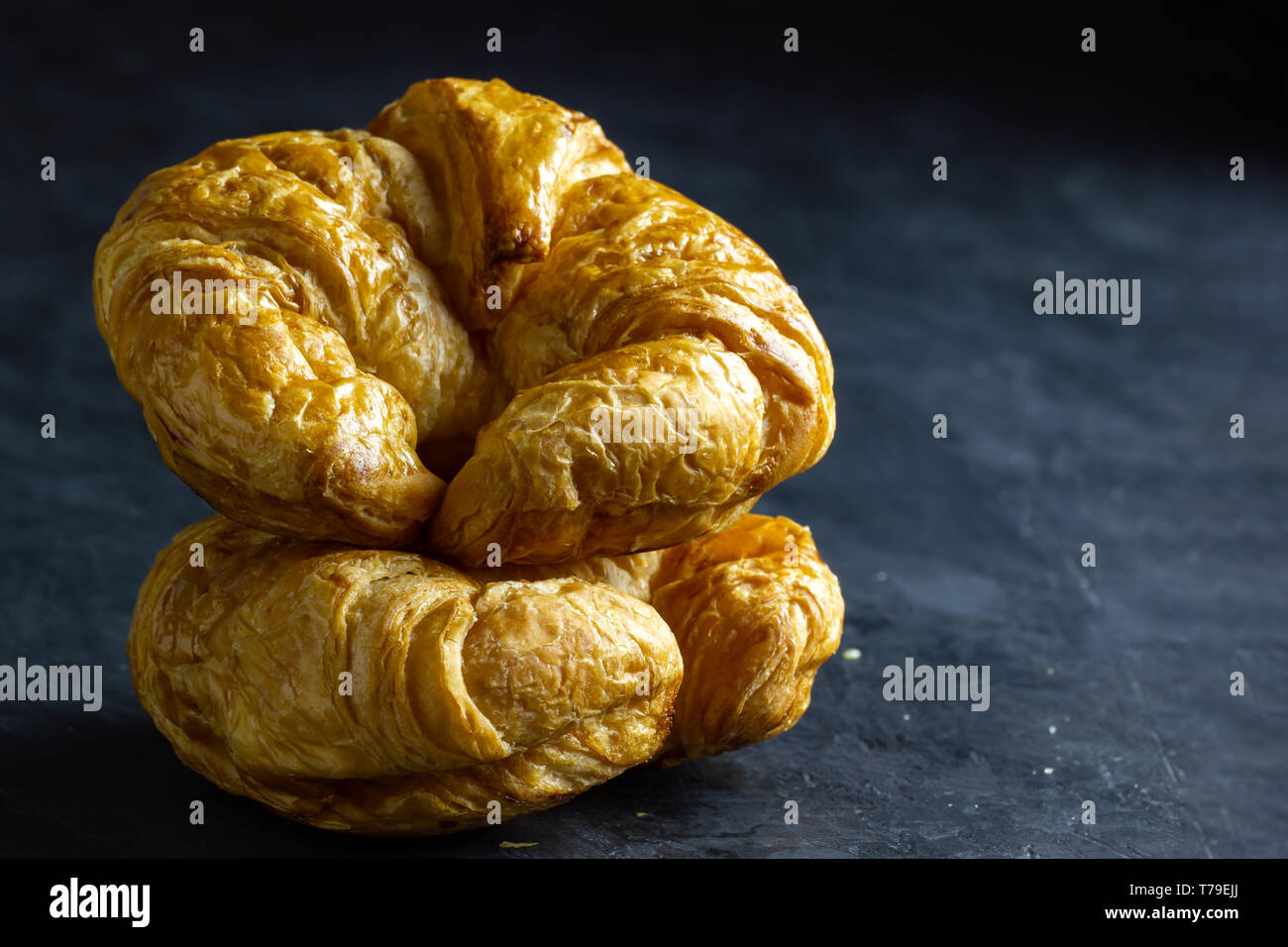 Croissant sur la table Gros plan sur fond sombre. L'espace de copie pour le texte. Banque D'Images