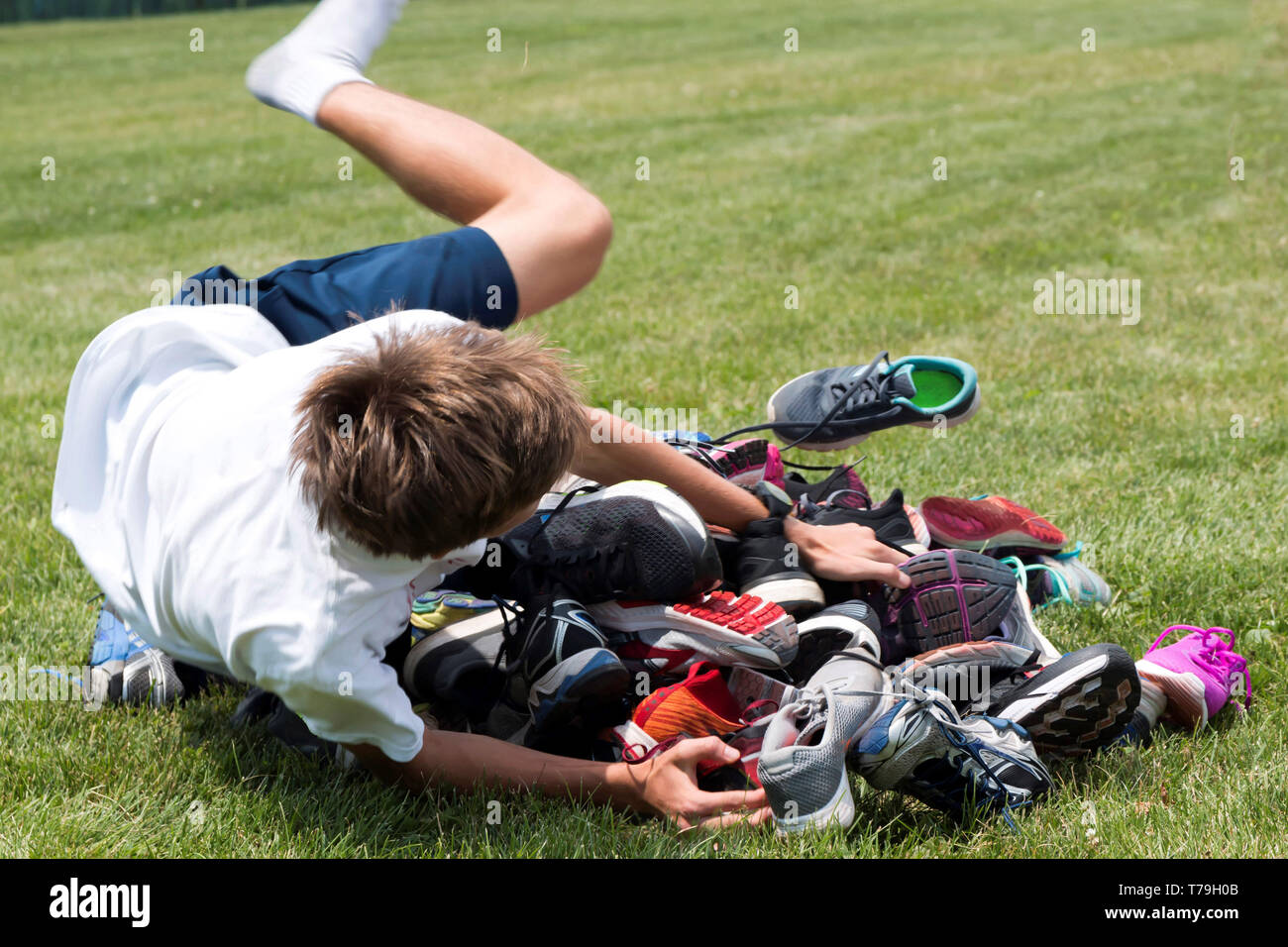 Un athlète à un camp d'exécution sprints dans un tas de chaussures de course dans le cadre d'un jeu appelé le jeu de la chaussure. Banque D'Images