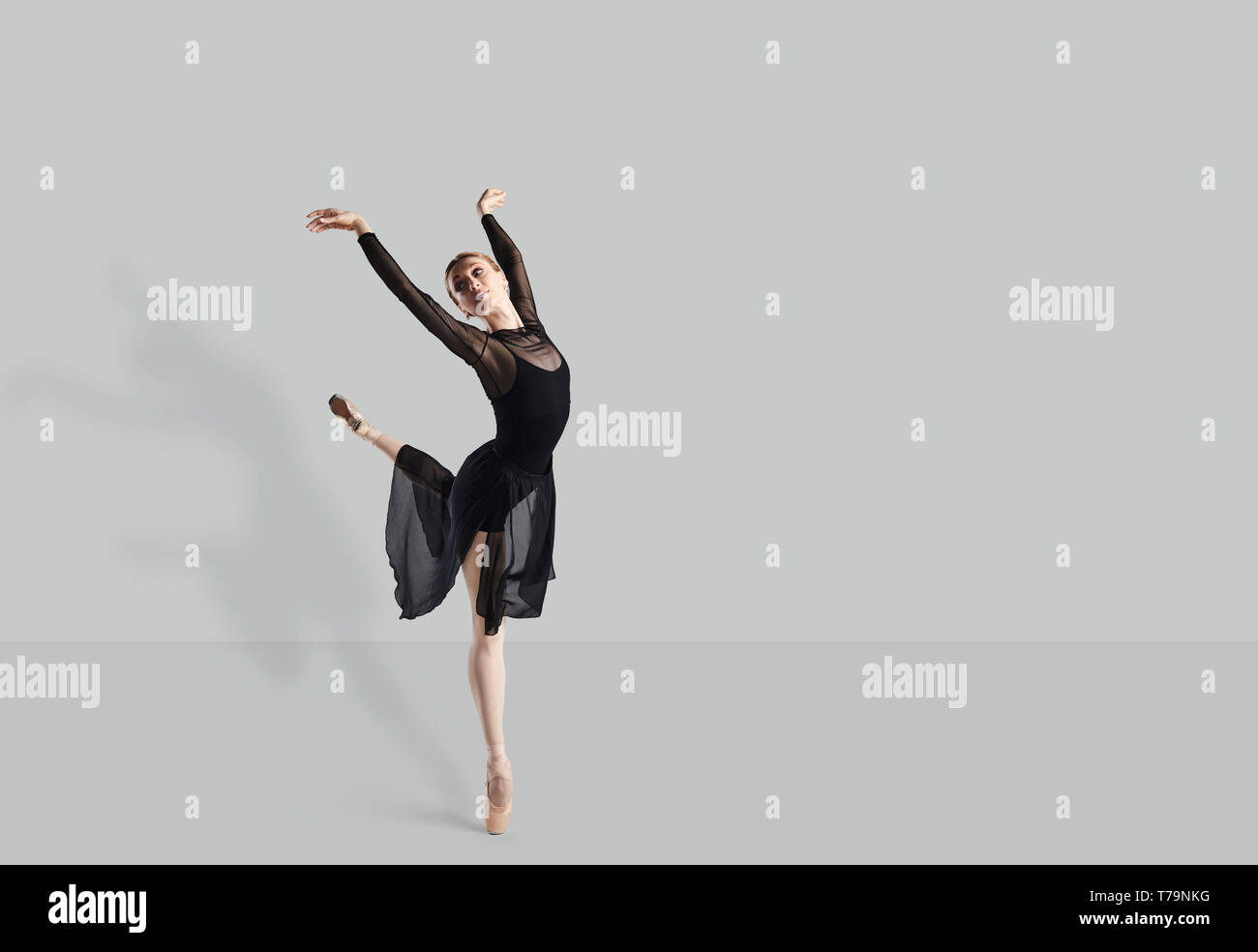 Femme danseuse de ballet dancer sur fond gris. Banque D'Images