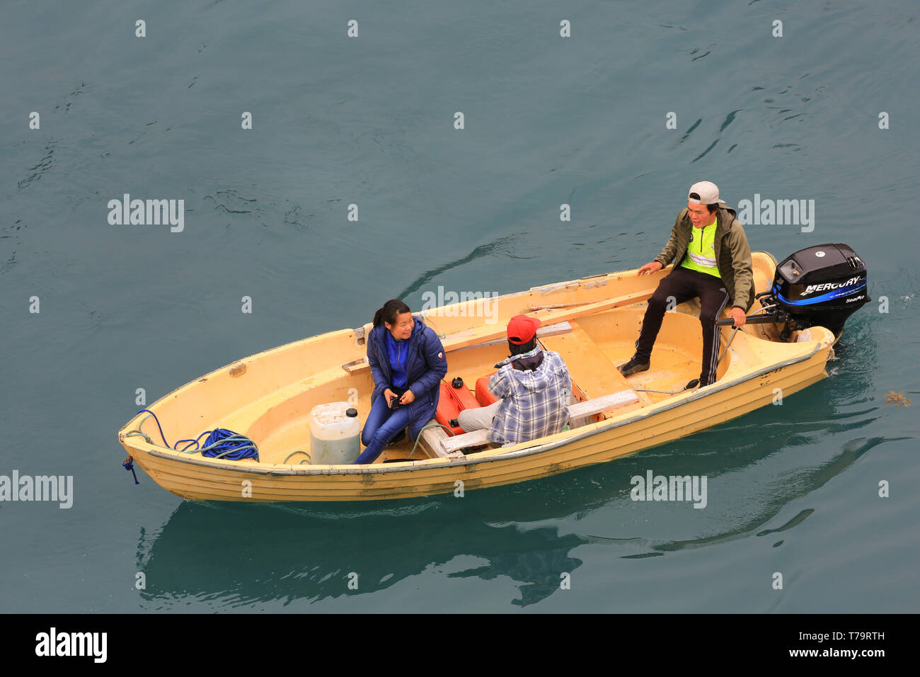 Trois sections locales de règlement dans le sud du Groenland Aappilattoq croisière salue les passagers de leur bateau à moteur. Banque D'Images