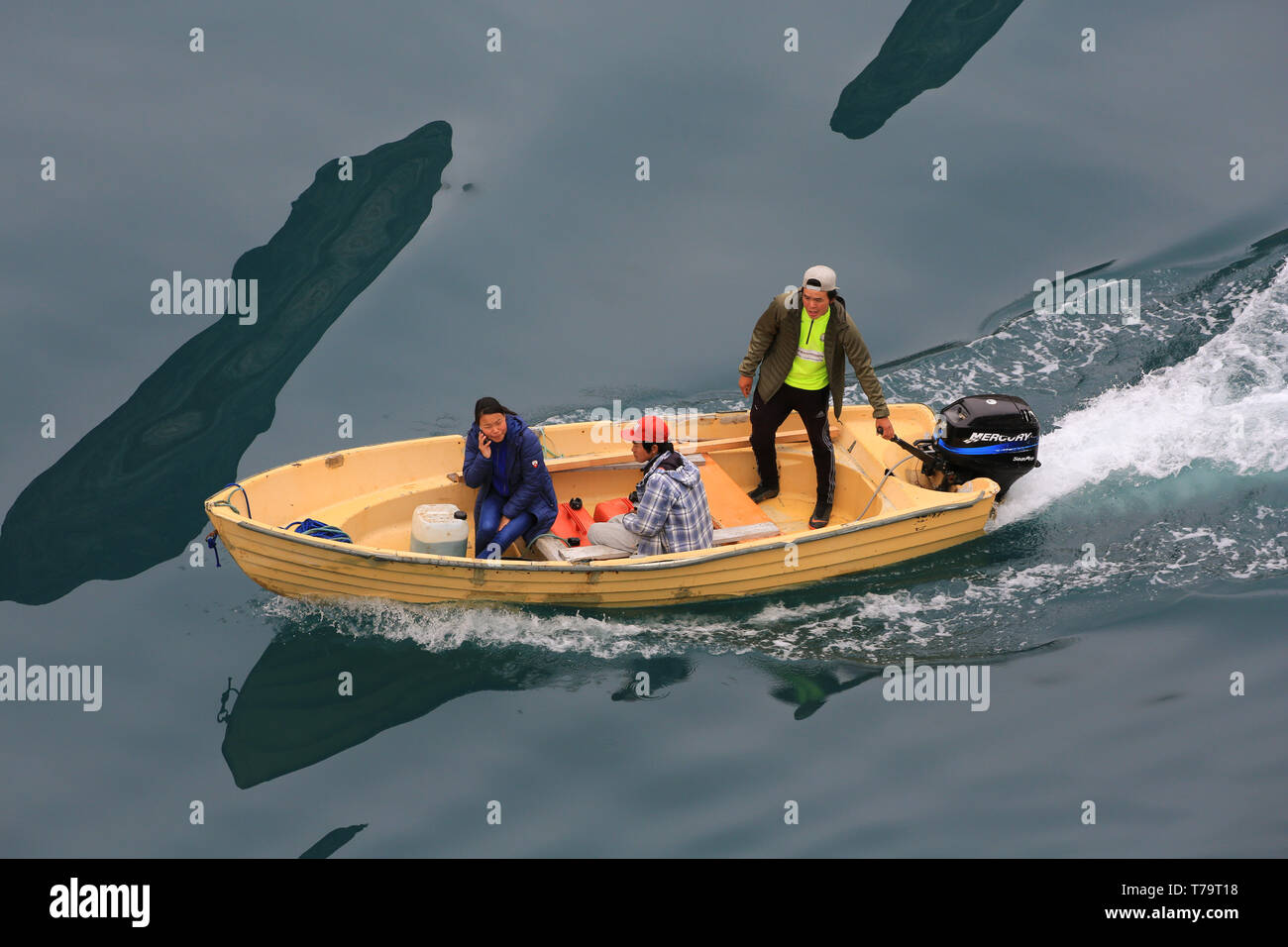 Trois sections locales de règlement dans le sud du Groenland Aappilattoq croisière salue les passagers de leur bateau à moteur. Banque D'Images