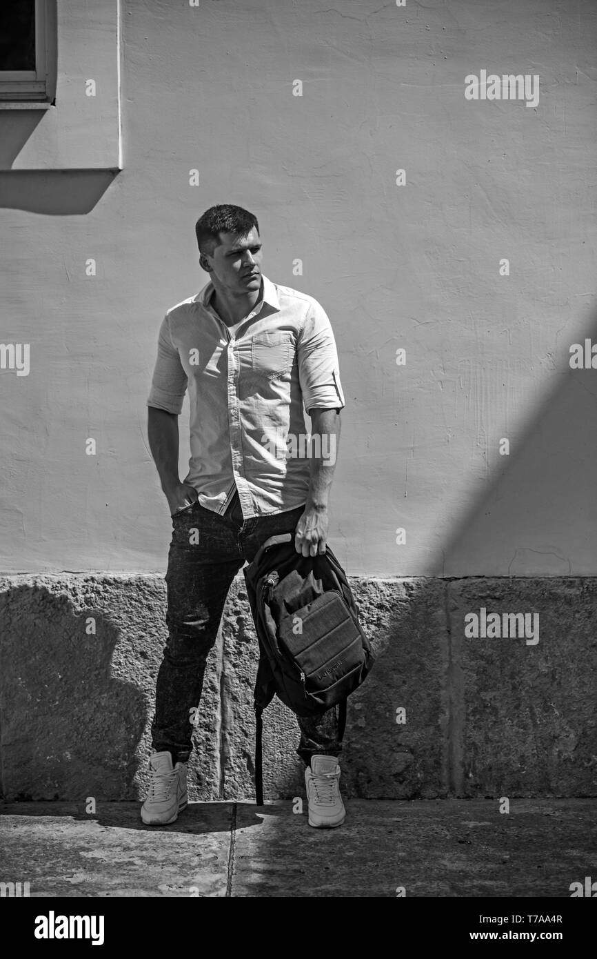 Jeune homme en train de marcher avec un sac à dos city Banque D'Images