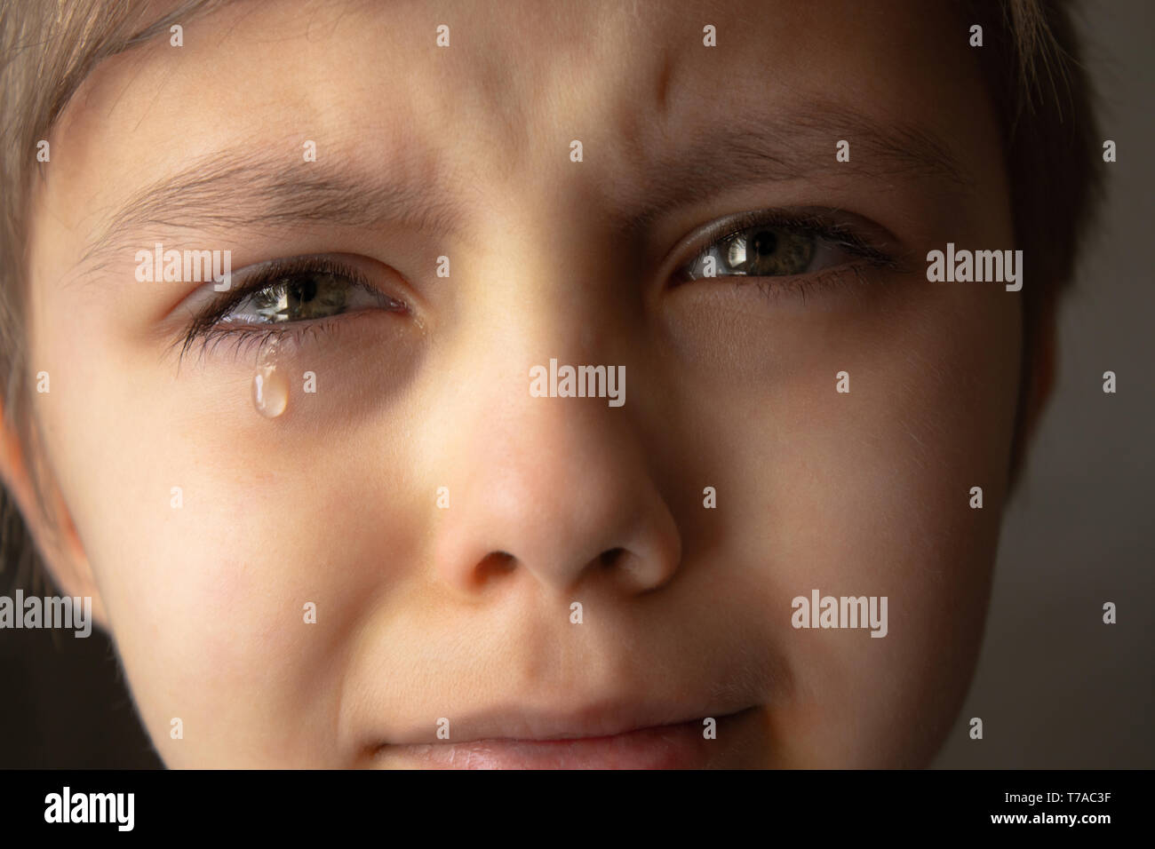 Des larmes dans les yeux d'un enfant. Une larme sur la joue du garçon. Close-up. Photo en noir et blanc. Banque D'Images