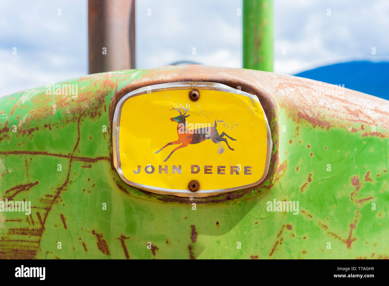 Rusy, ancienne tracteur John Deere, l'extrémité avant avec le logo complet, montrant les cerfs et les marques verbales. Vert et jaune de l'équipement agricole tracteur classique c Banque D'Images