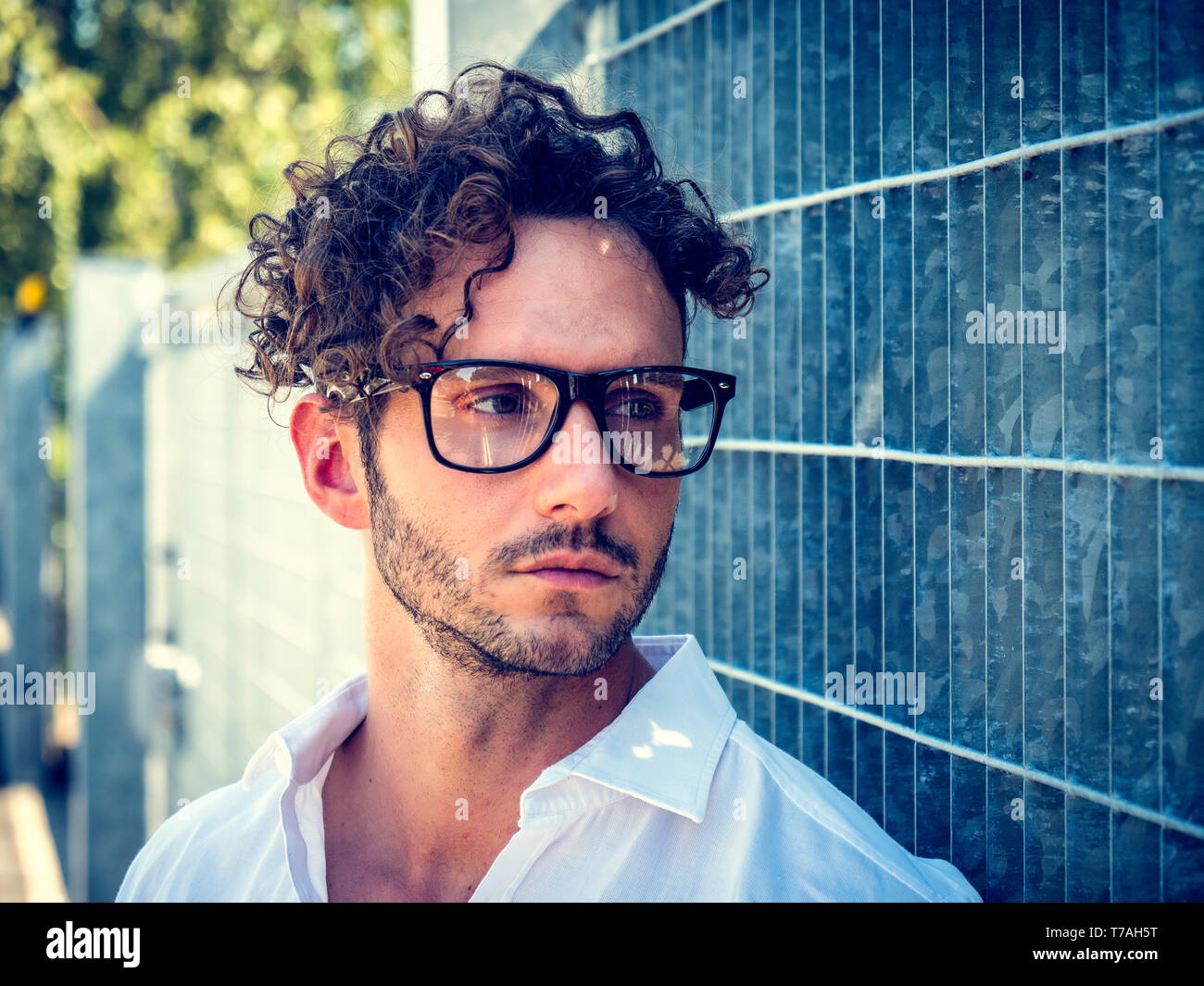 Un bel homme dans la configuration de la ville portant des lunettes Banque D'Images