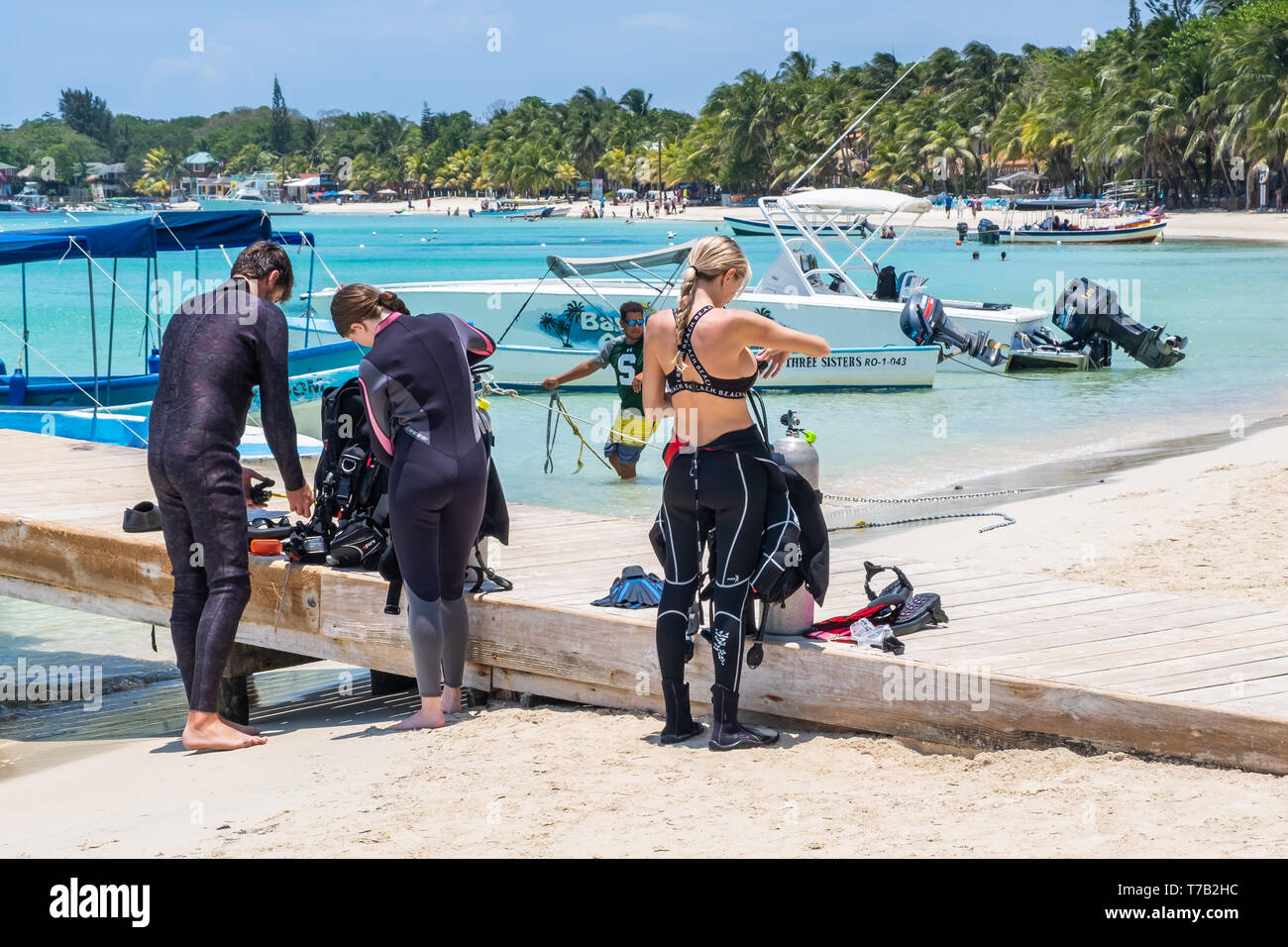 Les amateurs de plongée plongée à préparer sur la barrière de corail Mésoaméricaine au large de West Bay Roatan Honduras. Banque D'Images
